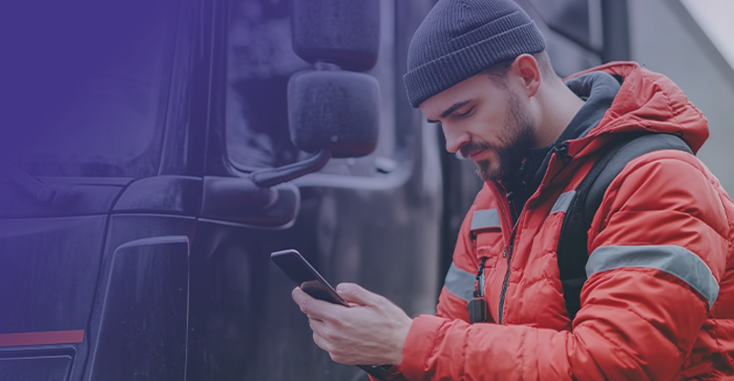 Lkw-Fahrer checkt Smartphone vor LKW