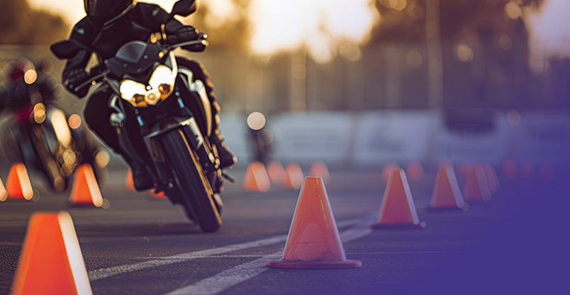Motorrad fährt Slalom um Pilone