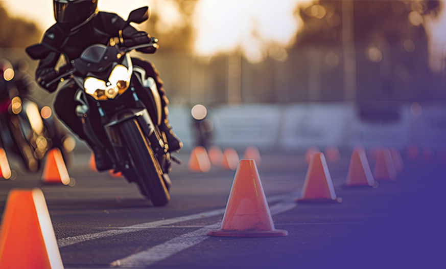 Motorrad fährt Slalom um Pilone